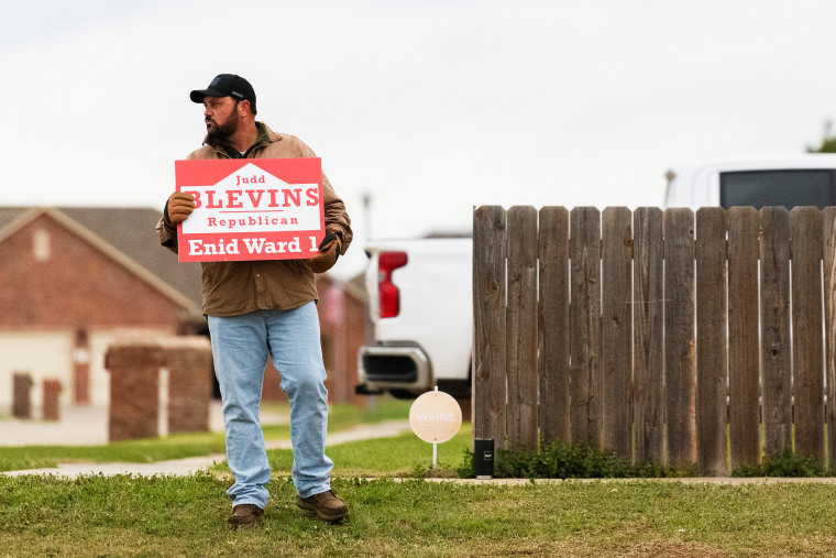 Judd Blevins holds a campaign sign in Enid.