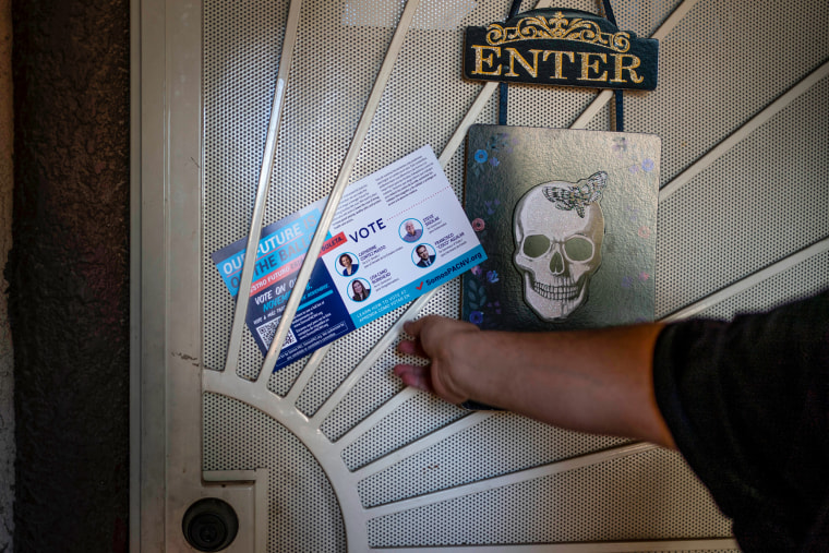 Victor Villenueva leaves a pamphlet at the door of a Nevada voter