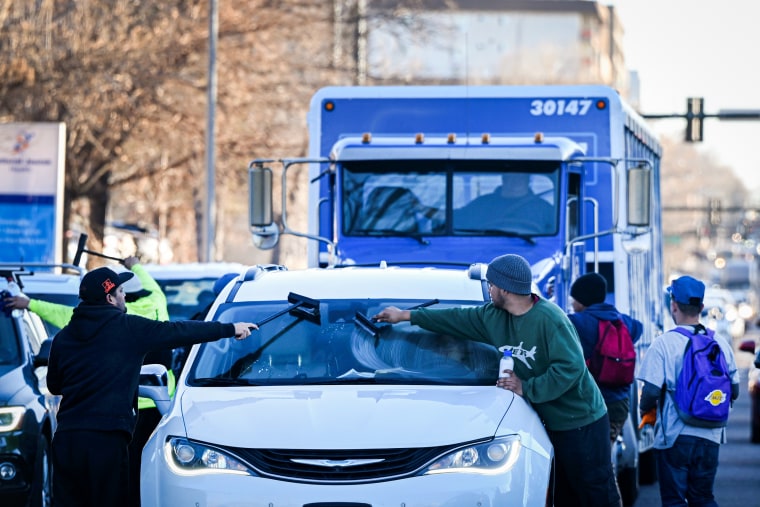 Migrants try to make money by cleaning windshields of drivers at stoplights.
